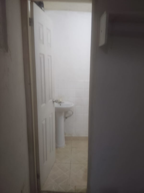 Compact bathroom with pedestal sink and tiled walls in room rental Nuevo Tocumen