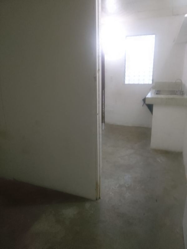 Simple utility kitchen area with sink concrete floors and glass block window in Panama rental