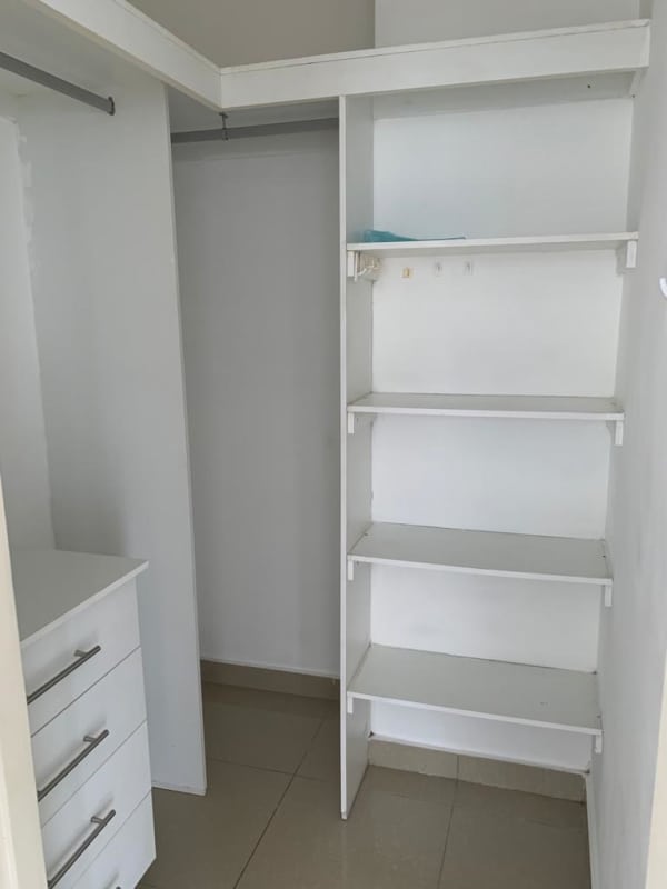 Walk-in closet with built-in white shelves and drawers in PH San Francisco Bay Panama City