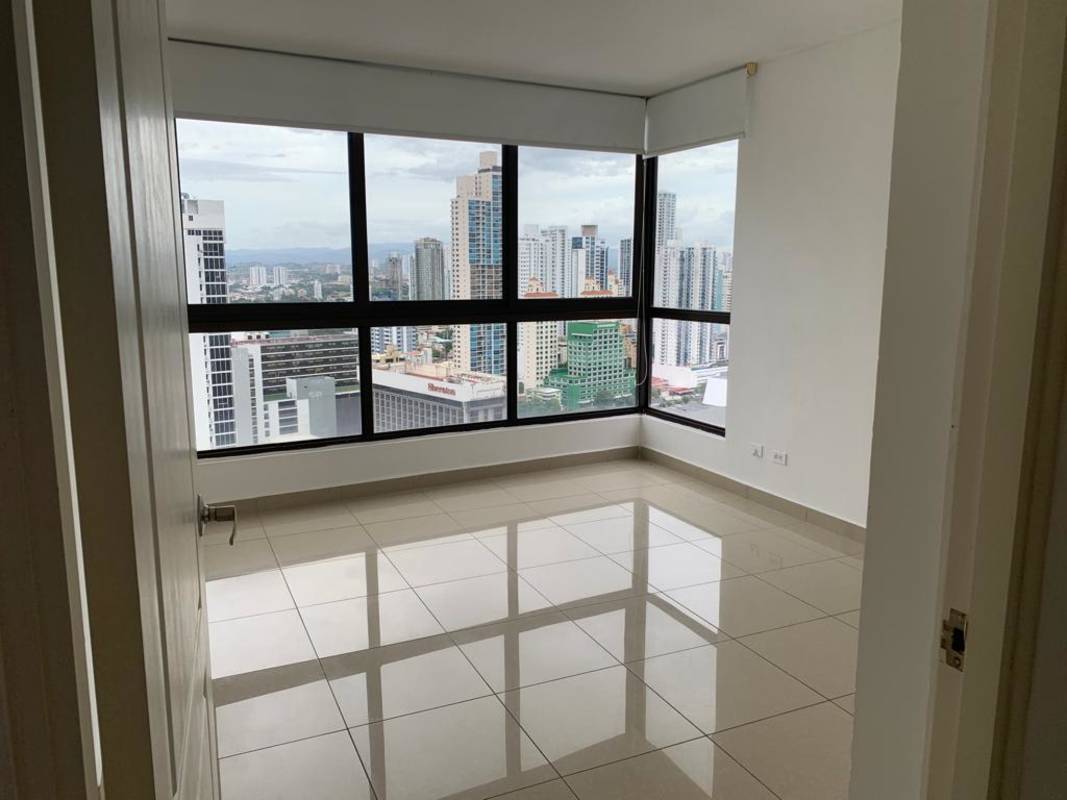 Bedroom featuring corner windows with urban skyline view PH San Francisco Bay Panama City