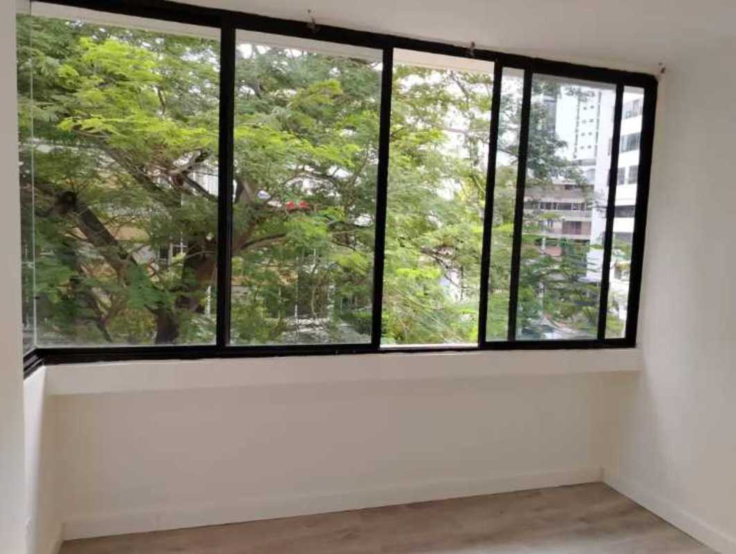 Living area with floor-to-ceiling corner windows overlooking city and greenery in PH Plaza 77 Vía Argentina Panama