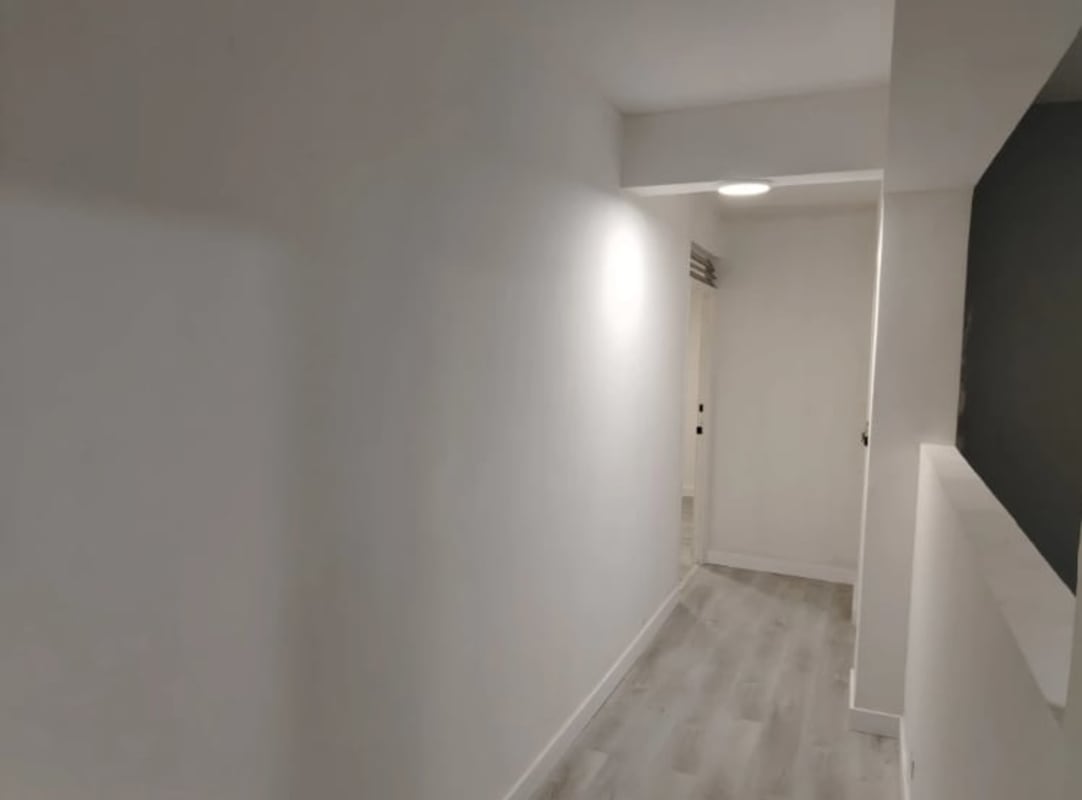 Hallway with recessed lighting, white walls, gray wood floors in PH Plaza 77 Via Argentina Panama City