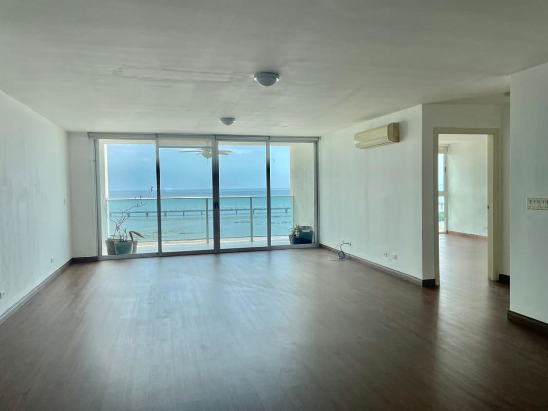 Modern living and dining area with large glass balcony doors and ocean views PH Aquamarina Panama City