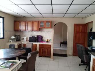 Kitchen with wood cabinets, tiled floors, dining space, archway in Volcán Chiriquí