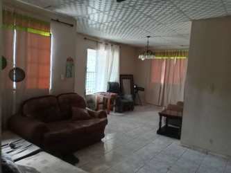 Casual living room with tiled flooring, brown sofas, curtains, Volcán Panama