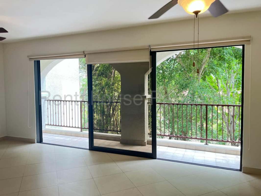 Bright bedroom with large window, ceiling fan, and built-in closet in Embassy Club Clayton Panama