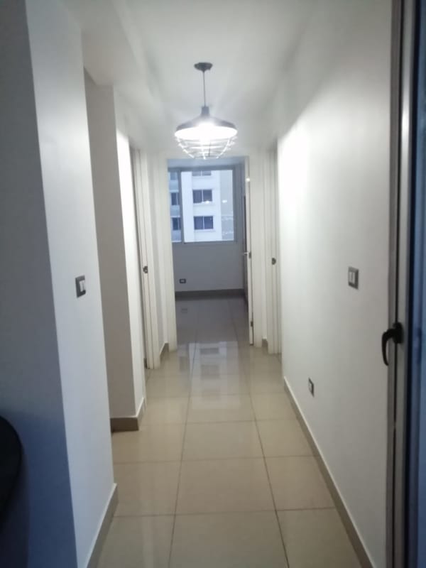 Hallway with doors to bedrooms, beige ceramic tiles, pendant light at PH Condado Gardens Panama