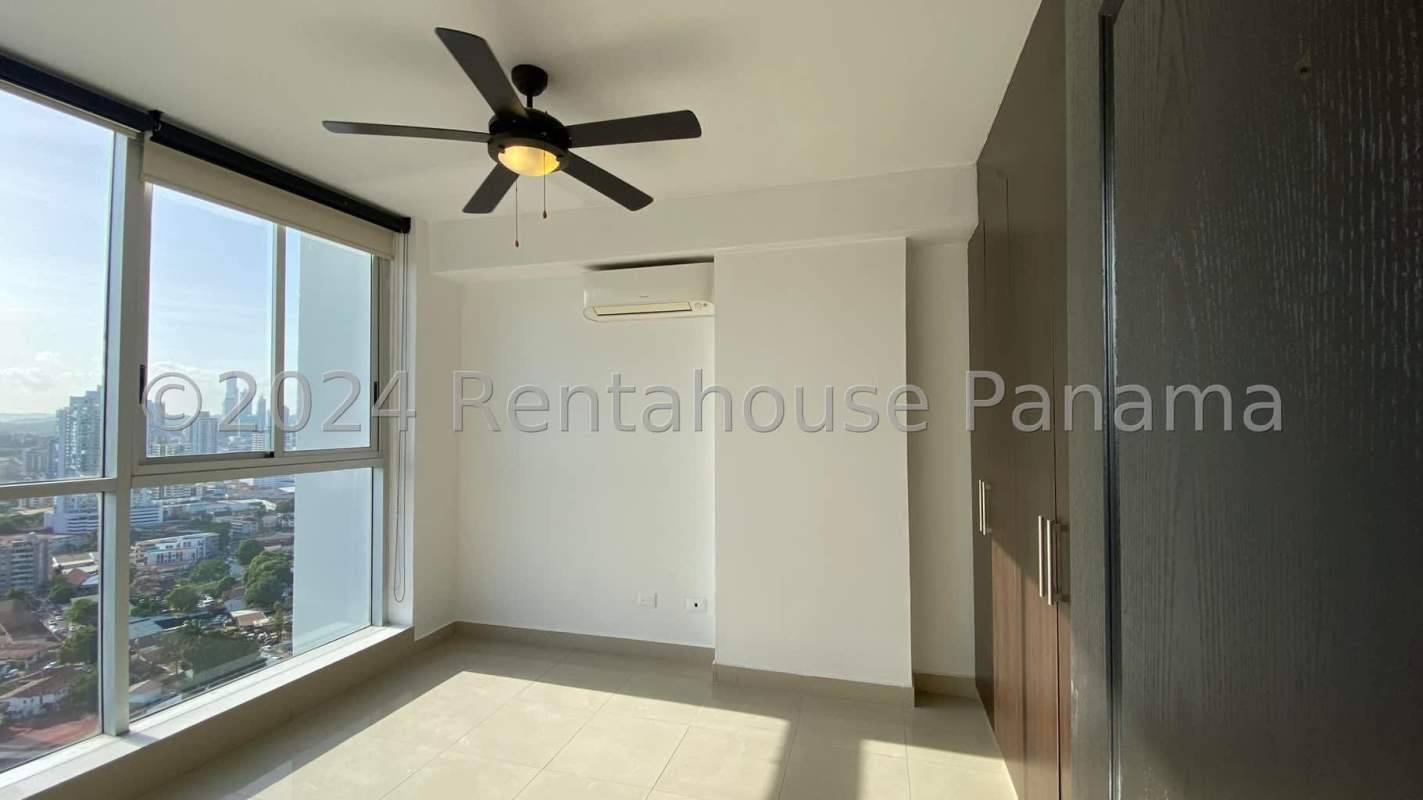 Bedroom with large window offering skyline view, ceiling fan, and AC PH Vitro Tower Panama City