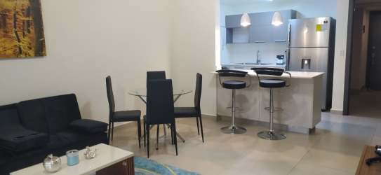 Modern open-concept living area with kitchen and dining in Panama Pacifico rental apartment