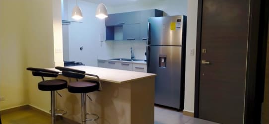 Kitchen with breakfast bar and modern appliances in Madeira Midrise Panama Pacifico apartment