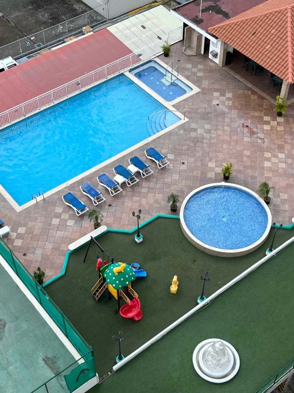 Outdoor pool area with city skyline view, lounge chairs and gazebo Panama apartment complex