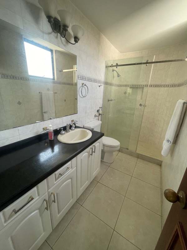 Modern bathroom with tiled walls, vanity, and glass shower at PH Lexus Tower San Francisco
