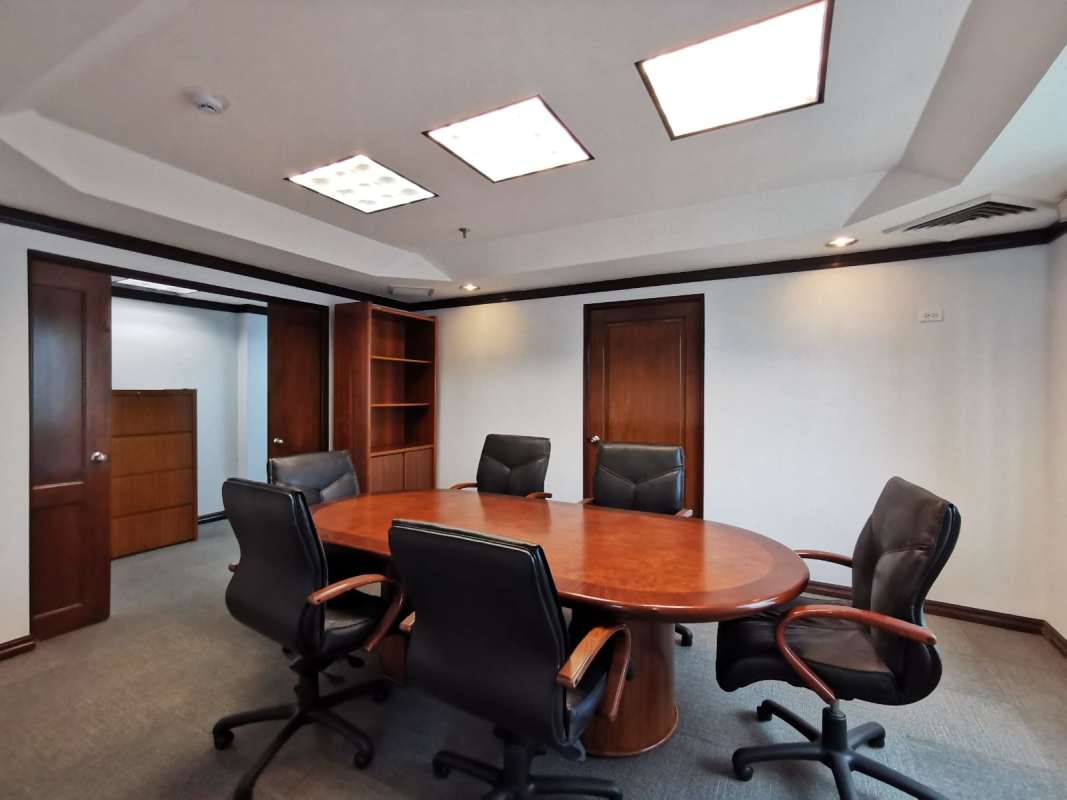 Professional conference room with oval wooden table black leather chairs and carpet in World Trade Center Panama
