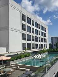 Infinity swimming pool area with sun loungers at PH Centriqo Panama Pacifico