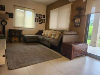 Bright living room with tiled floors large windows sectional sofa in Woodlands Panama