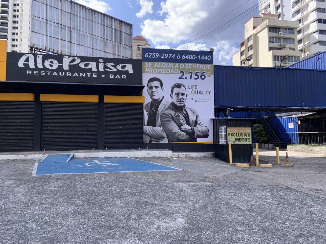Commercial corner with parking lot and billboard signage on Via España close to El Cangrejo Obarrio Panama City