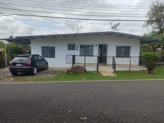 Street view of single story home with security bars porch and driveway La Chorrera