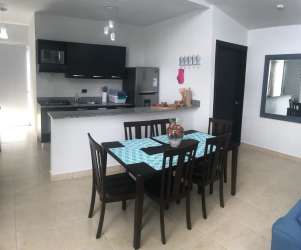 Large open living dining area with blue sofa and TV in Ibiza Residence Playa Bijao Panama