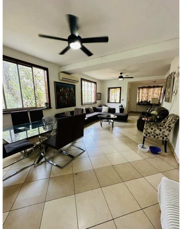Dining area with large windows, ceiling fan overlooking greenery Panama house