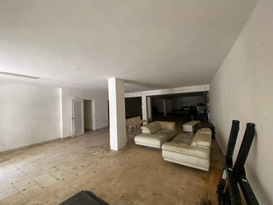 Large open-plan tiled interior space with cream sofas for rent in PH Distrito Plaza Panama