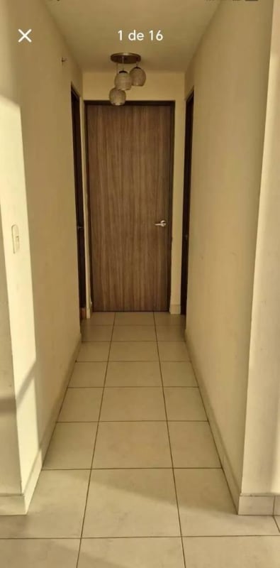 Interior hallway with tiled floor, cream walls and wooden doors in Torres de Cantabria Panama