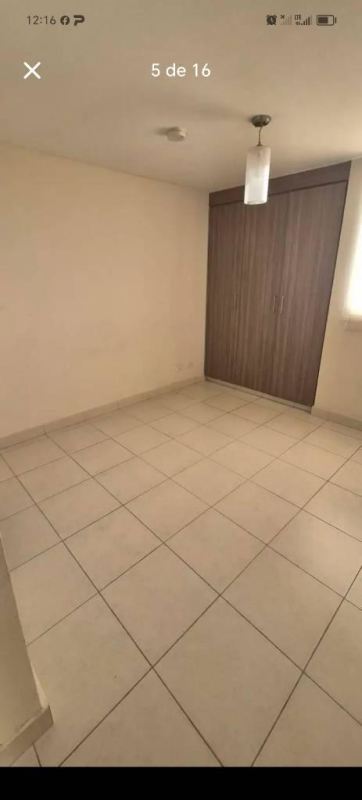 Compact kitchen with granite countertop, laundry sink, and cabinets in Torres de Cantabria apartment Panama City