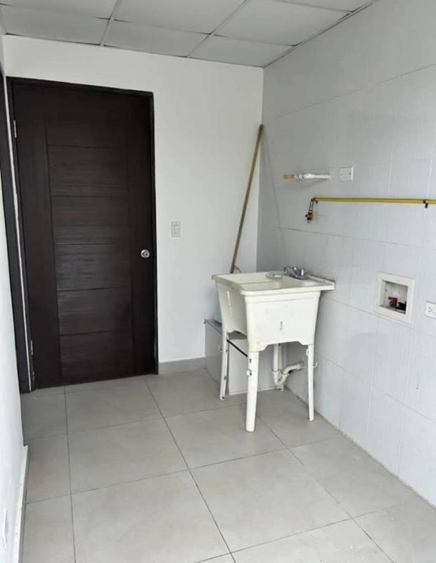 Laundry room with tile walls, sink, mop, and space for washer in duplex house Betania Panama