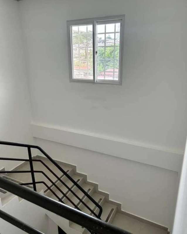 Private backyard with green lawn, covered patio area and garden in duplex house Betania Panama