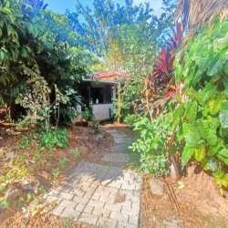 Single story house with covered carport front porch surrounded by gardens in Tinajas Dolega Panama