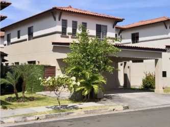 Two-story Mediterranean-style home with clay tile roof, landscaped yard, carport in Palmia Panama Pacifico