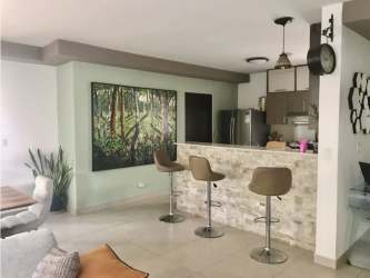 Spacious open kitchen and dining area with stone bar, pendant lighting in Palmia Woodlands Panama