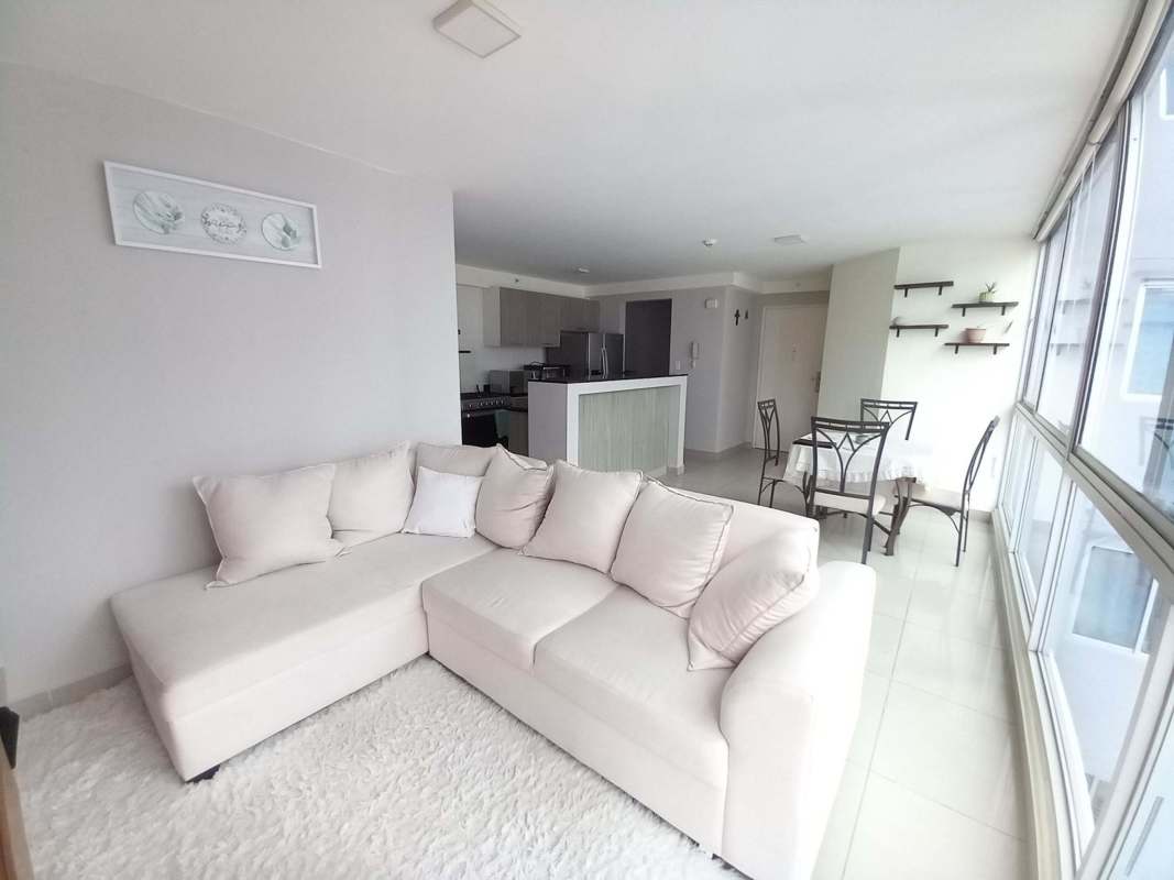 Living and dining room with floor-to-ceiling windows, sectional sofa and open kitchen PH Coral Tower Panama