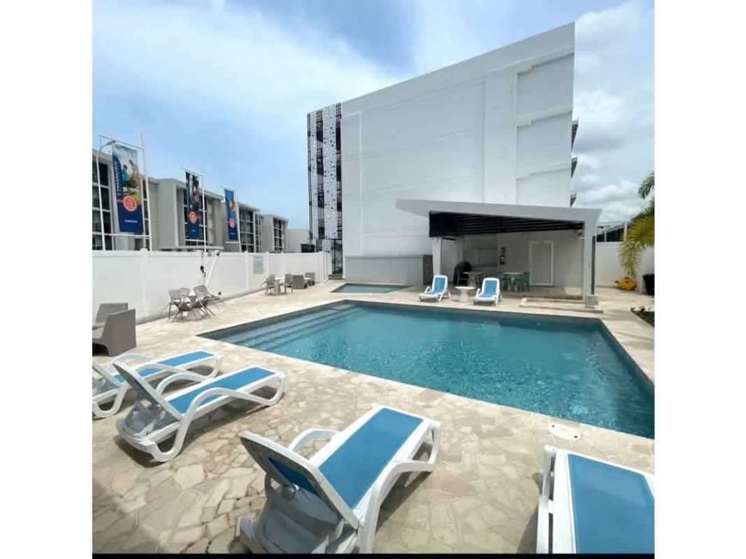 Outdoor pool with sun loungers and social amenities at Panama Viejo Residences