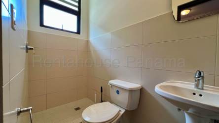 Living room with vaulted ceiling and large glass doors opening to garden in Nativa Panama Pacifico