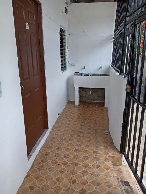 Outdoor laundry space with sink, security gate and tiled floor in affordable rental San Miguelito