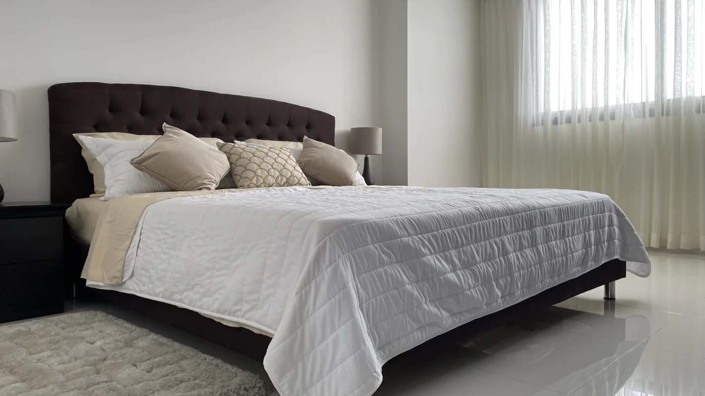 Spacious bedroom with tufted headboard, large window and neutral décor in PH Cosmopolitan