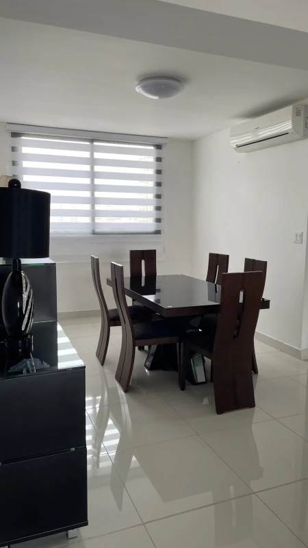 Modern dining area with dark wood table, large window and AC PH Cosmopolitan Panama
