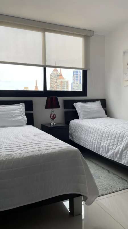 Bedroom with twin beds, city skyline view, tile floors in El Cangrejo Panama apartment