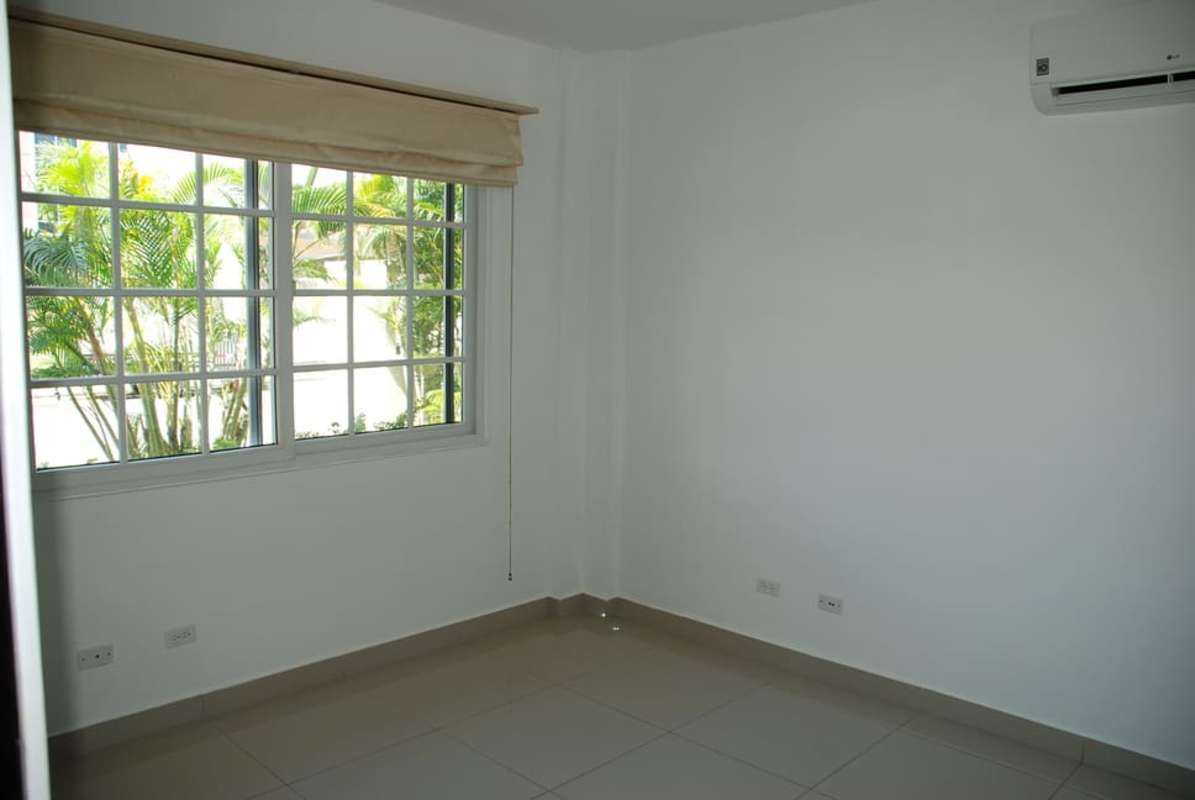 Bright bedroom with large grid window and modern finishes Costa Sur Panama