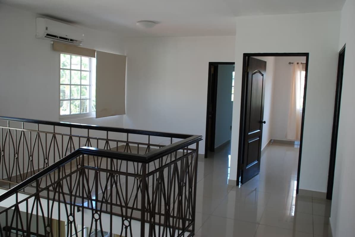 Spacious foyer with large windows, black framed doors and staircase at Costa Sur Panama house