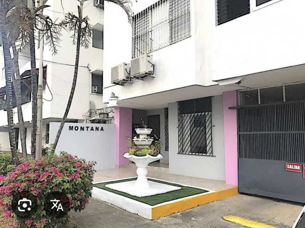 Front view of PH Montana apartment building with fountain flower beds and gated entrance Parque Lefevre Panama City