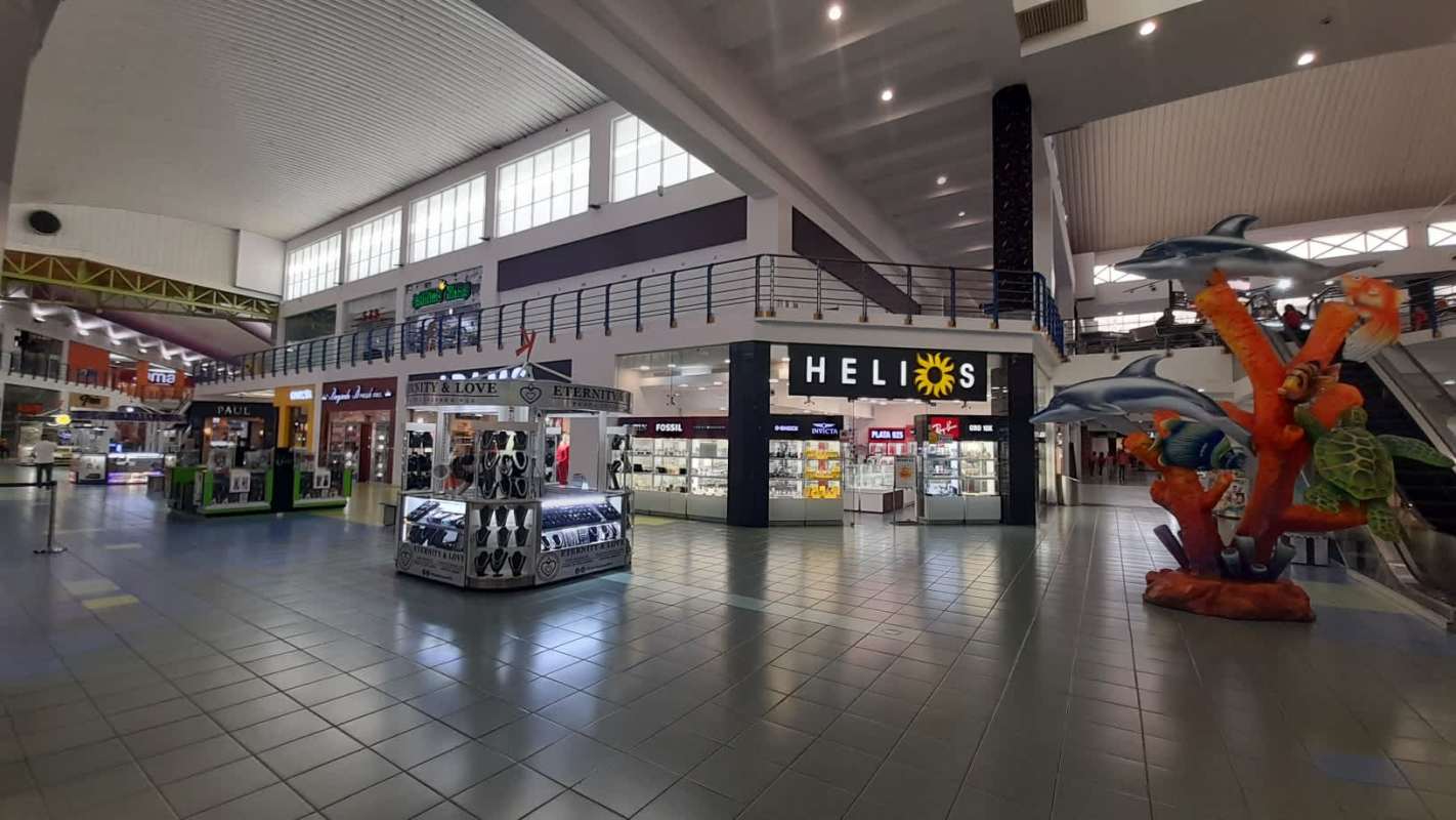 Wide interior of Albrook Mall with retail shops and pedestrian pathways in Panama