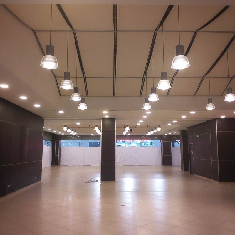 Empty commercial unit with large open floor and pendant lights at Albrook Mall