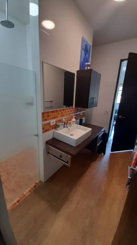 Modern bathroom with walk-in glass shower vanity Altos de Golf residence Panama