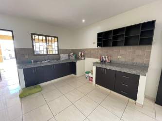 Spacious kitchen with granite countertops dark cabinets tile floors in David Panama house for rent