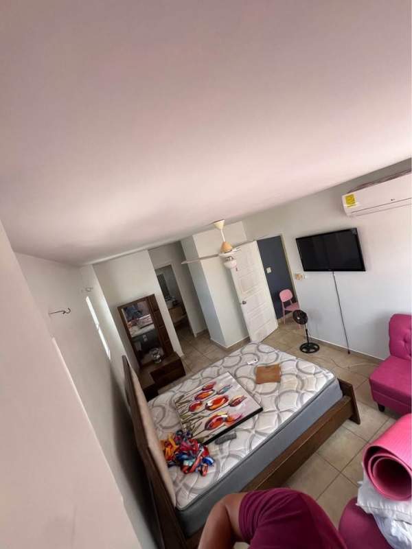 Furnished master bedroom with ceiling fan, AC, wardrobe, and ceramic tile floors at PH Everest Brisas del Golf Panama