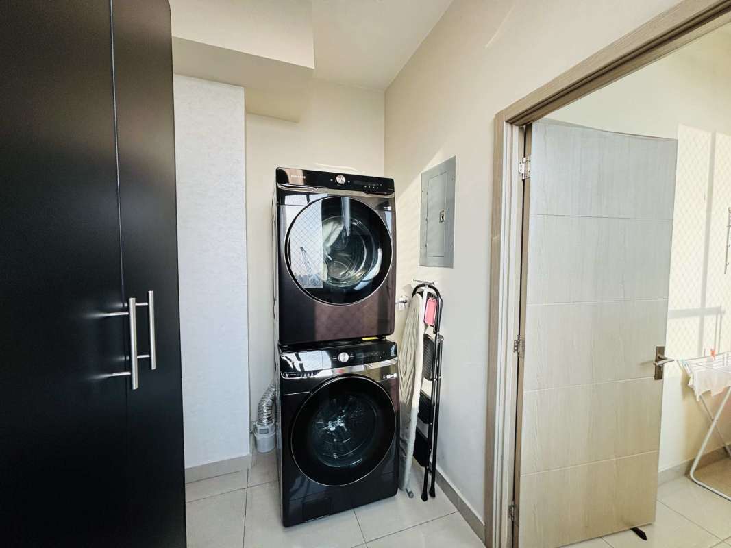 Modern laundry room with washer and dryer, storage cabinets at Quartz Tower Coco del Mar Panama