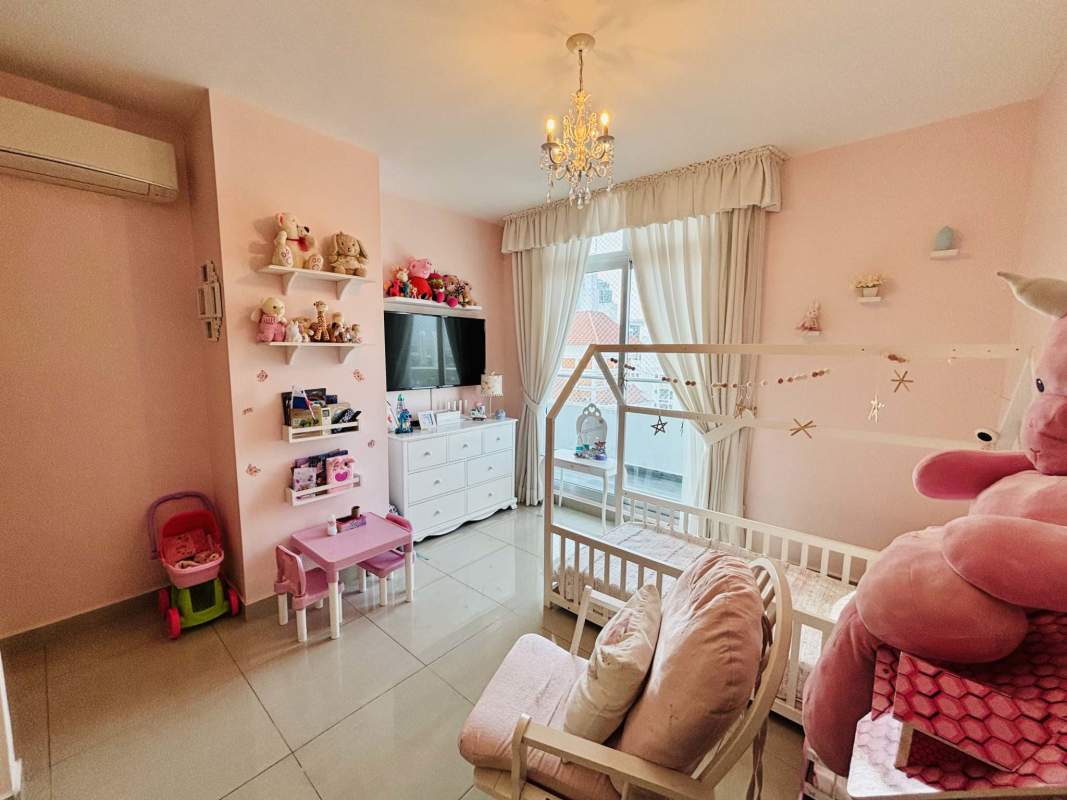 Children's bedroom with pink decor, toys, and large window in Quartz Tower Coco del Mar Panama