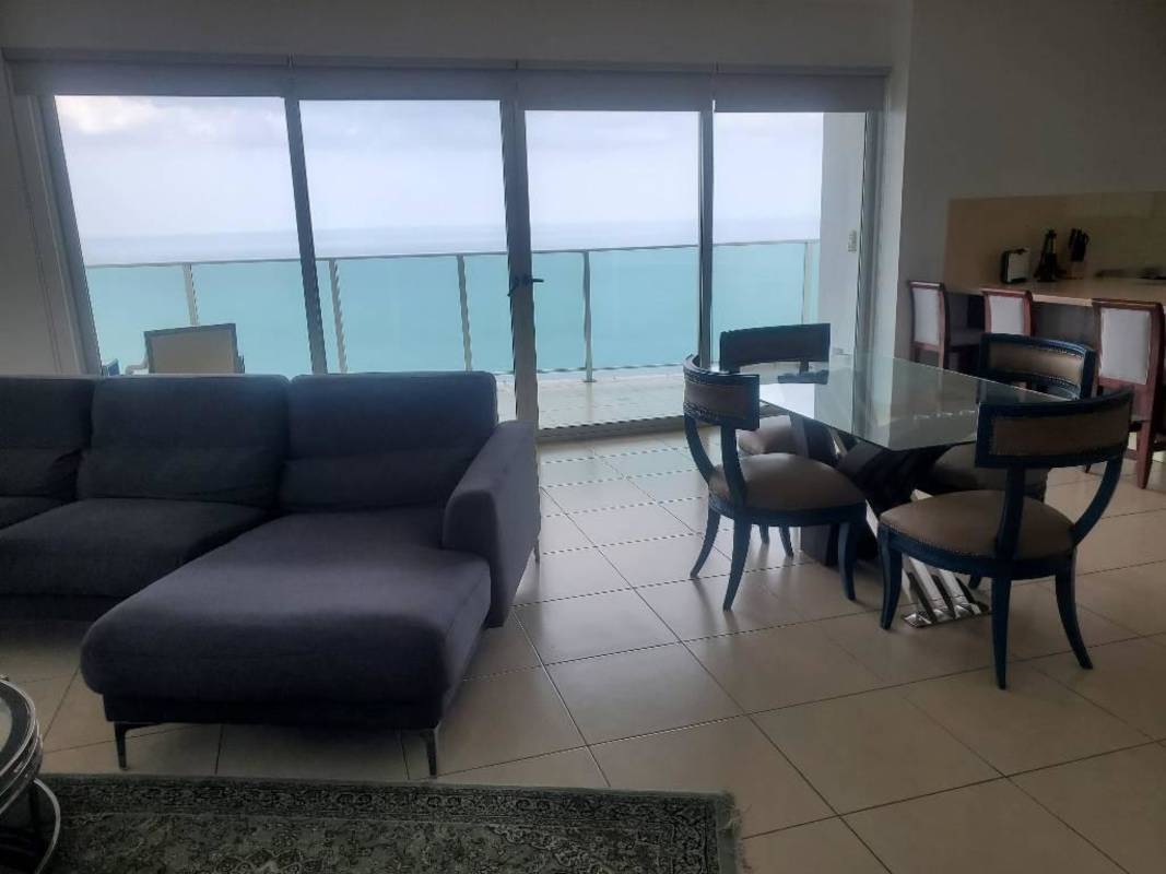Modern open living and dining room with floor-to-ceiling windows and ocean views in PH Oasis on the Bay Punta Pacifica