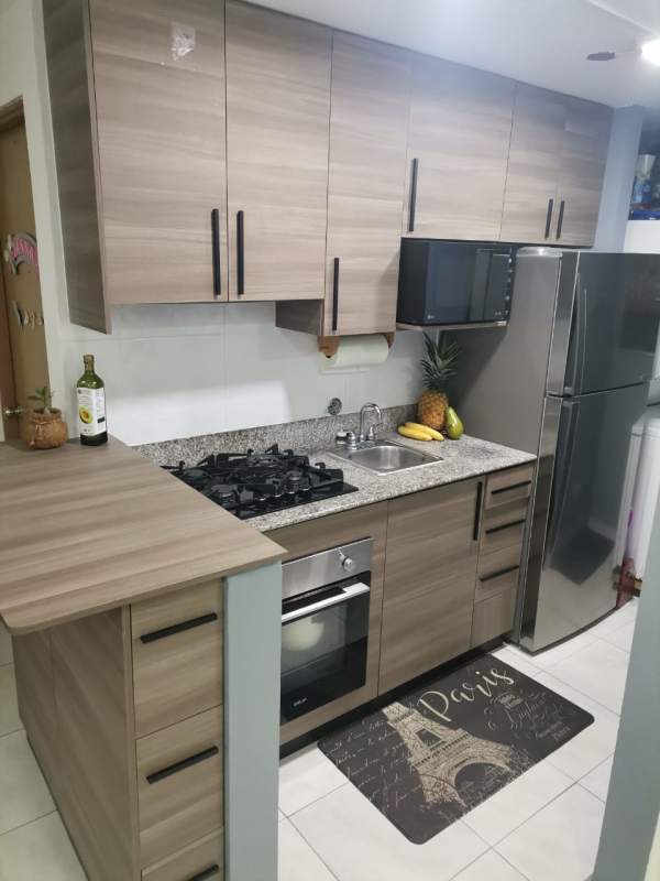 Contemporary kitchen and dining area with wood cabinets and appliances in Llano Bonito Panama